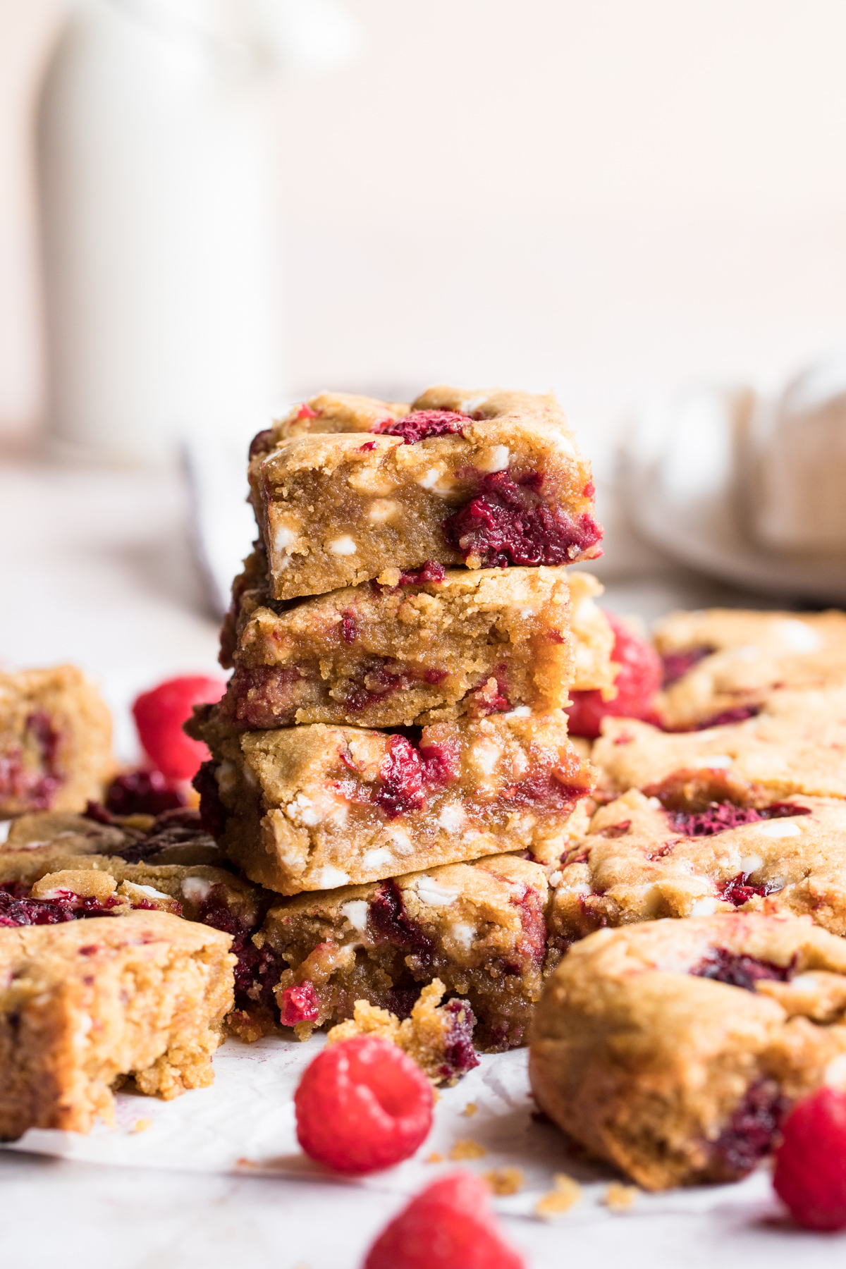 side view of 4 stacked raspberry blondie squares on a marble background