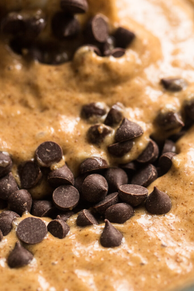 super close up shot of chocolate chips being mixed into batter