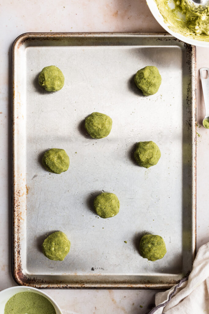 top down view of balls of dough of matcha cookies on a sheet pan